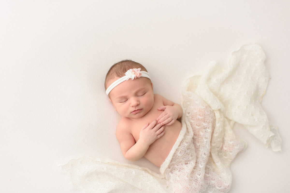 a all white backdrop and blanket around a baby boy indoors
