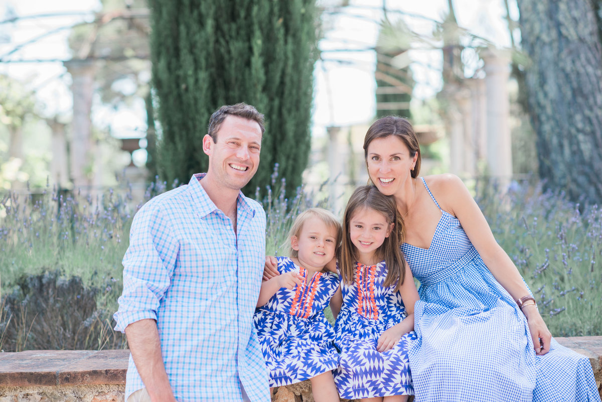 family of four in blue dresses and shirt at vineyard in southern France