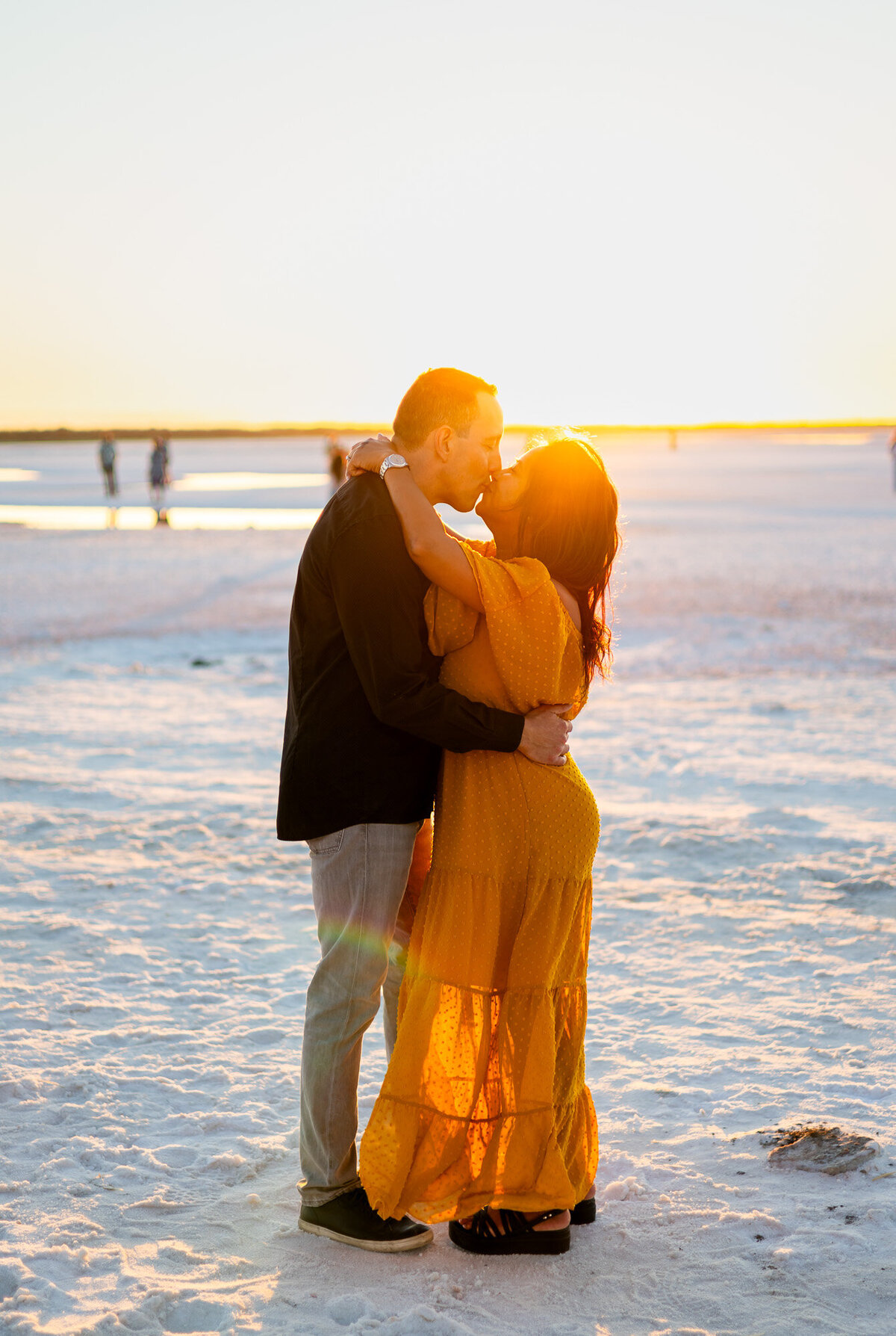 Couple kissing on bright white salt flats at sunset with soft golden light – Bay Area Couples Photography Portfolio - Ellobelle Photography