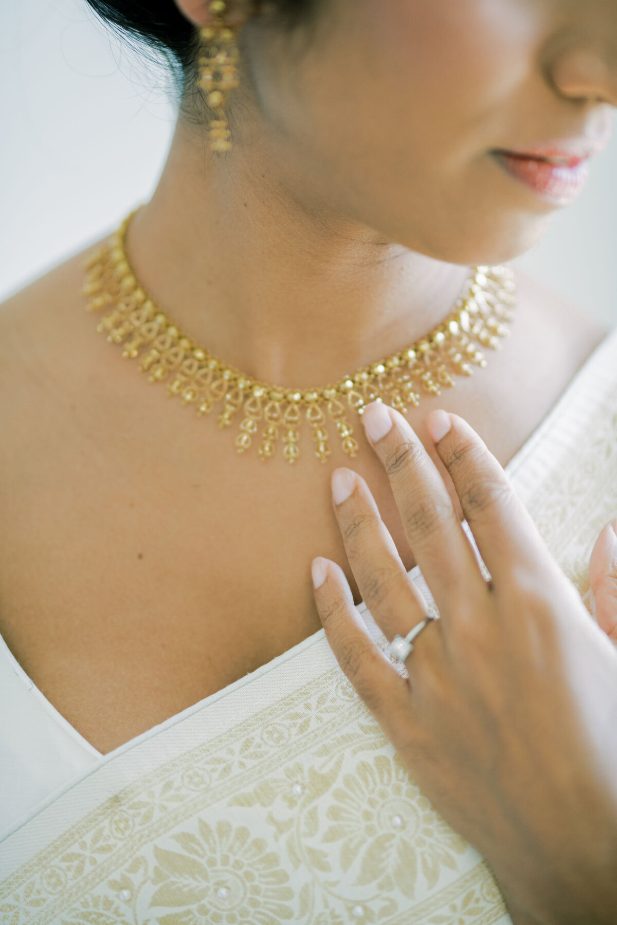 bride has her hand on necklace.
