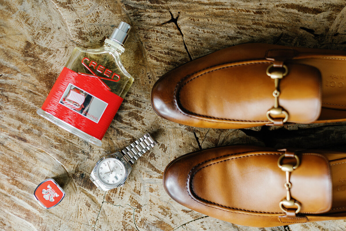 Jonathan’s stylish wedding details, featuring Gucci loafers, cologne, and cigar accessories, carefully arranged for the wedding at Table Key, Islamorada. Photography by Claudia Amalia.