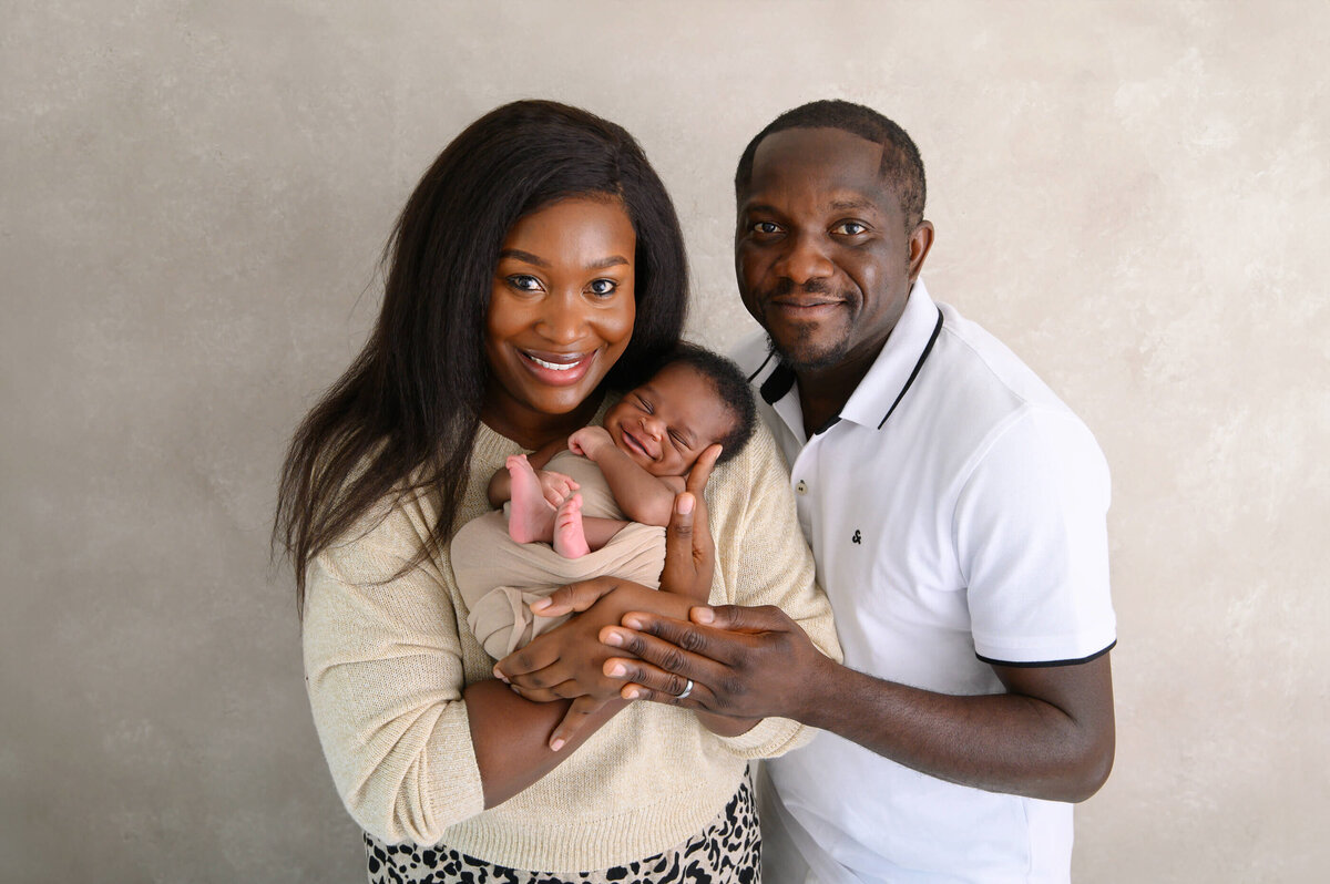 Mom and dad holding newborn baby boy for their family newborn photography session in Burlington, Ontario.
