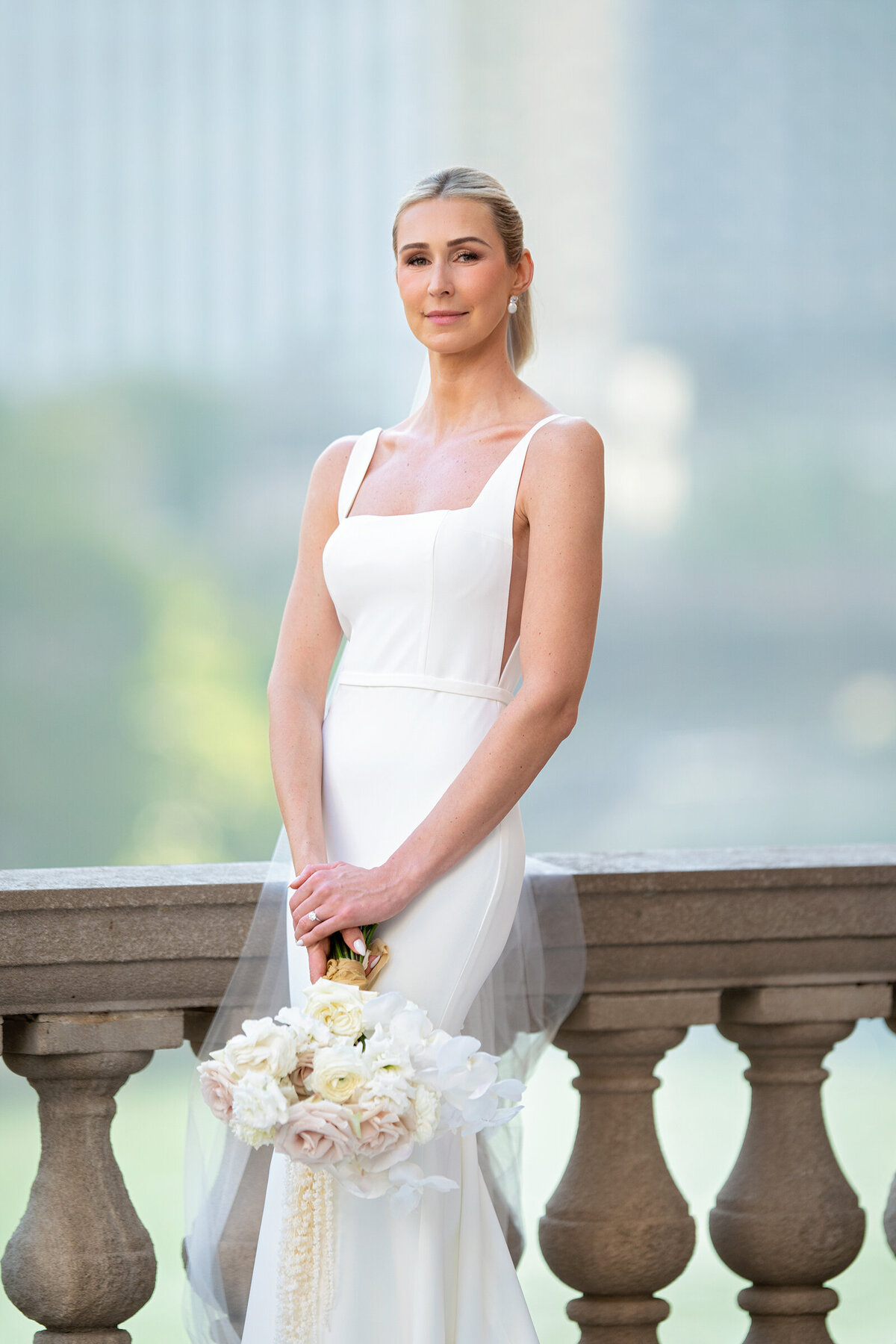 elegant bride wearing  wearing  "made with love" designer wedding dress  holding white flower  bouquet