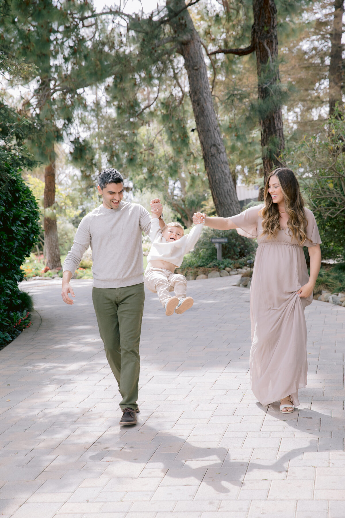 Two parents swinging their child up in between them