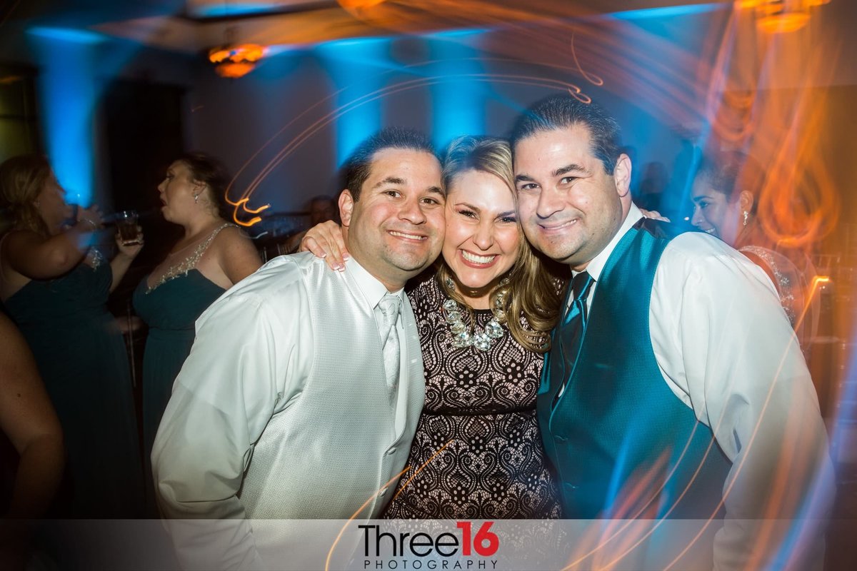 Guests smile while on the dance floor at wedding reception