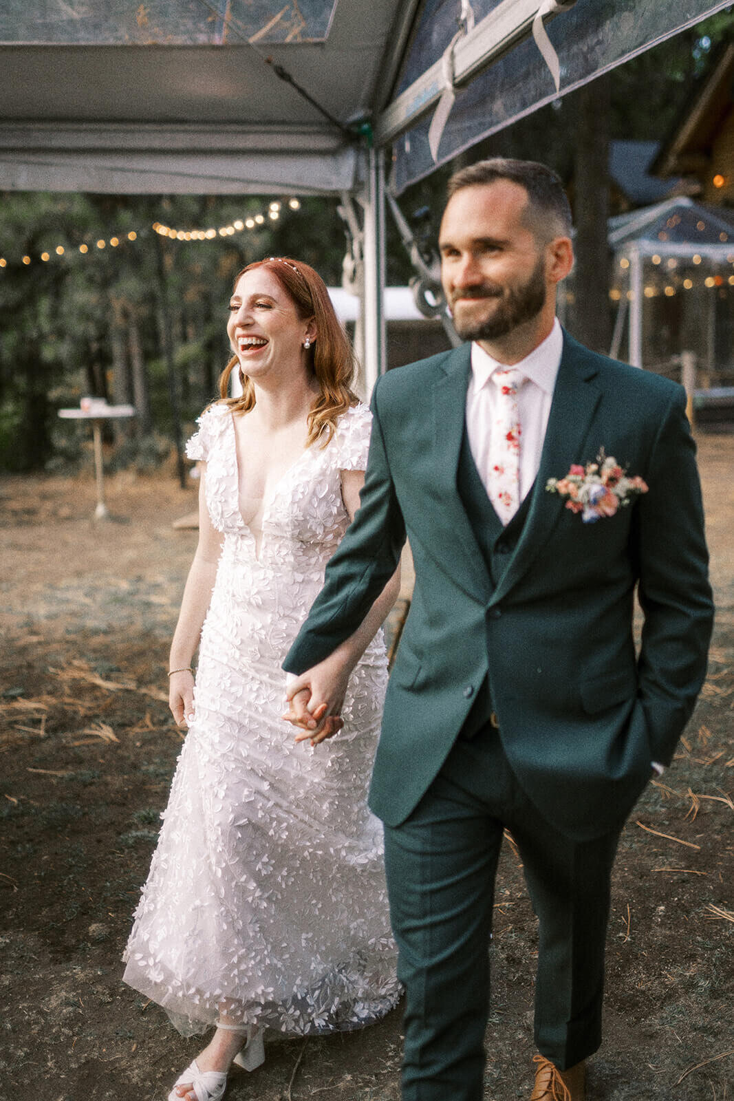 A bride and group holding hands and smile at their outdoor Lake Lodge Wedding.