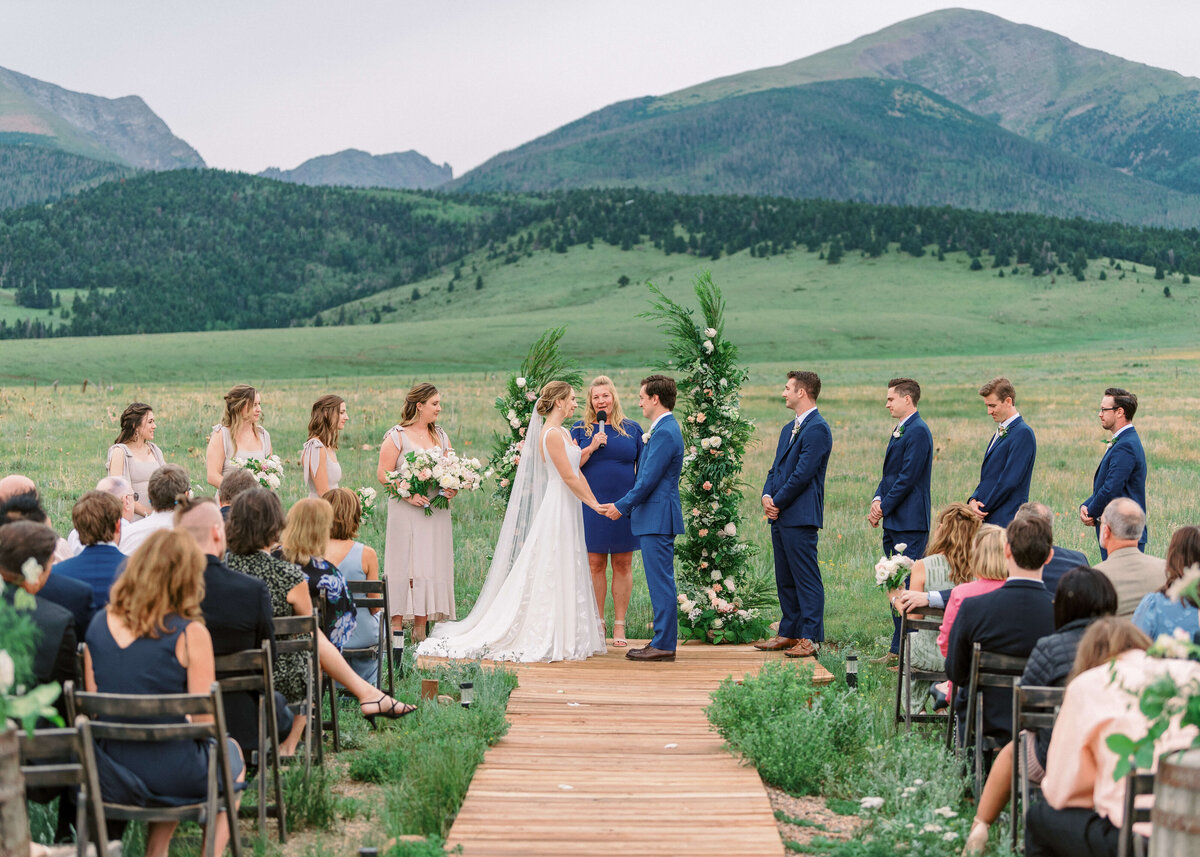 A bride and groom share vows at the outdoor alter while surrounded by their friends and family in an image by Virginia wedding photographer