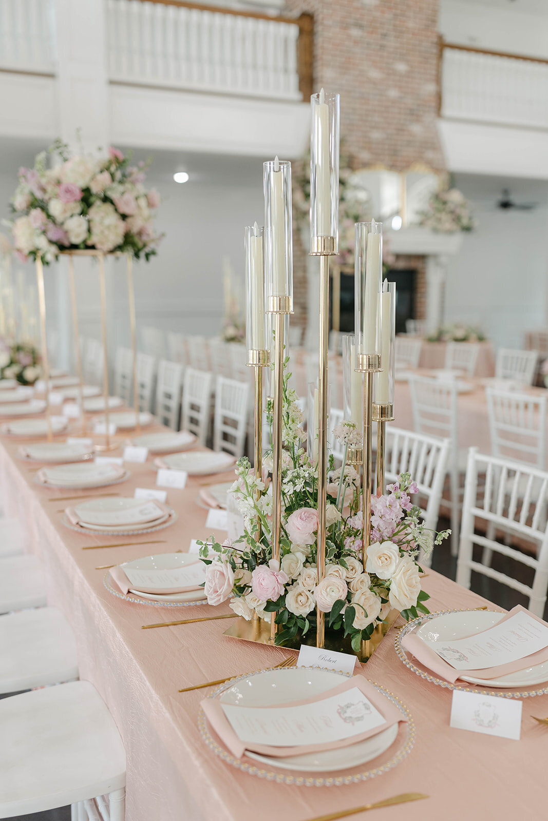 Wedding table decorated with chargers, dinner plates blush linens and napkins with flowers