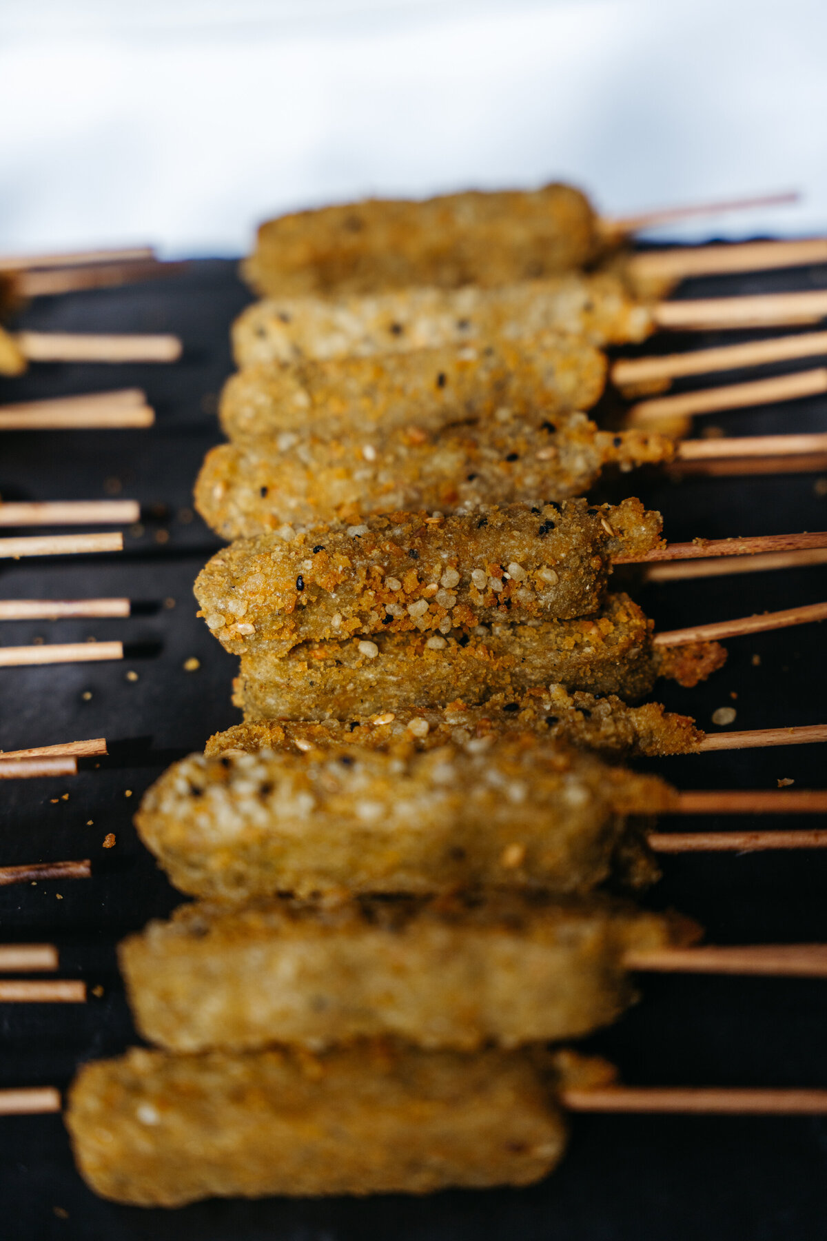 Skewers of breaded vegan appetizers on grill