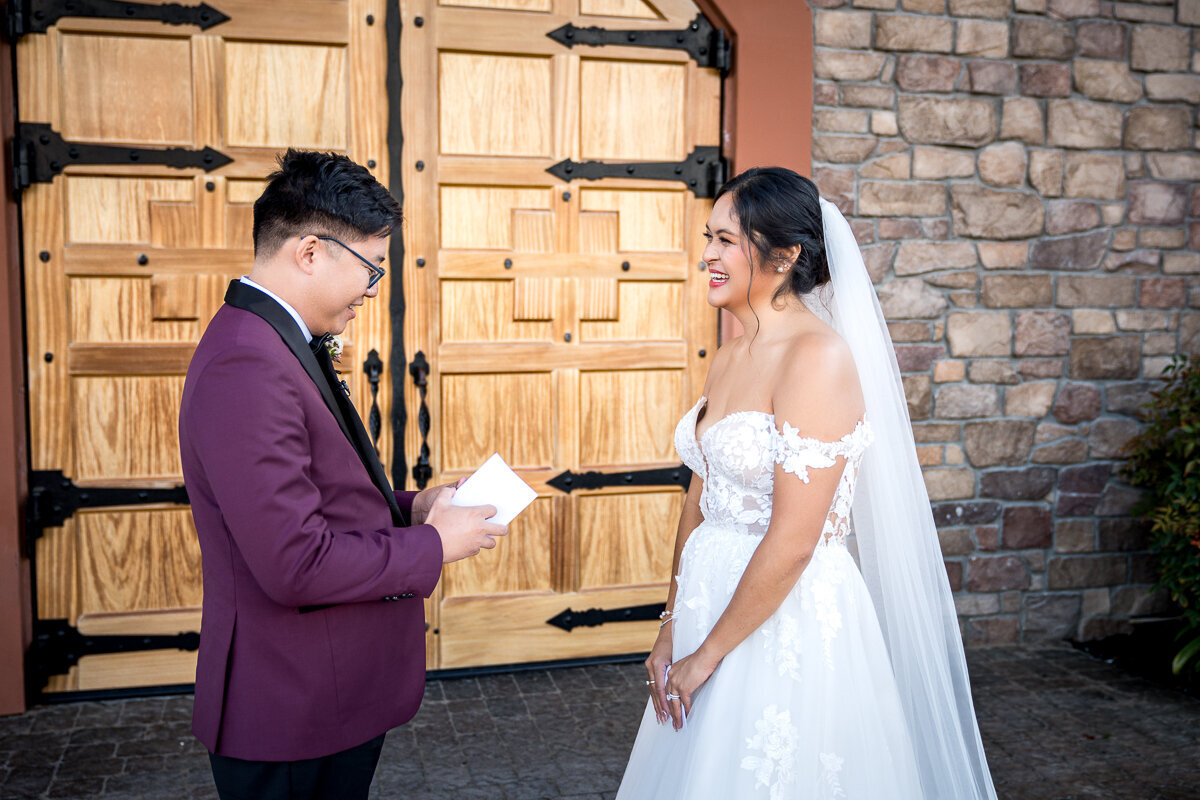 A heartfelt moment as a groom reads his vows to his bride in front of the elegant Casa Real at Ruby Hill Winery in Pleasanton, CA, capturing the emotion and romance of their wedding day.