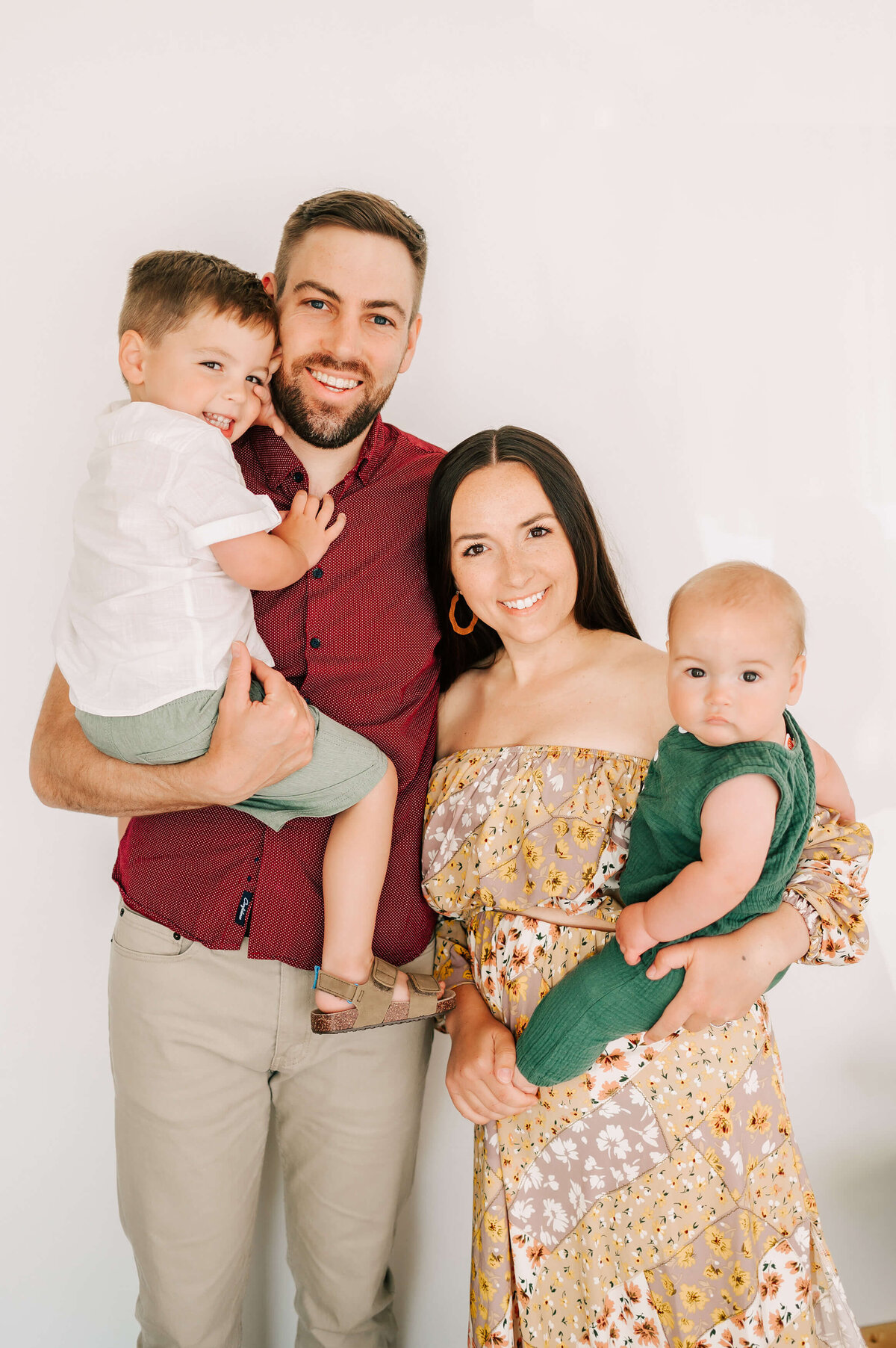 Family standing and smiling in family photography studio in Springfield MO