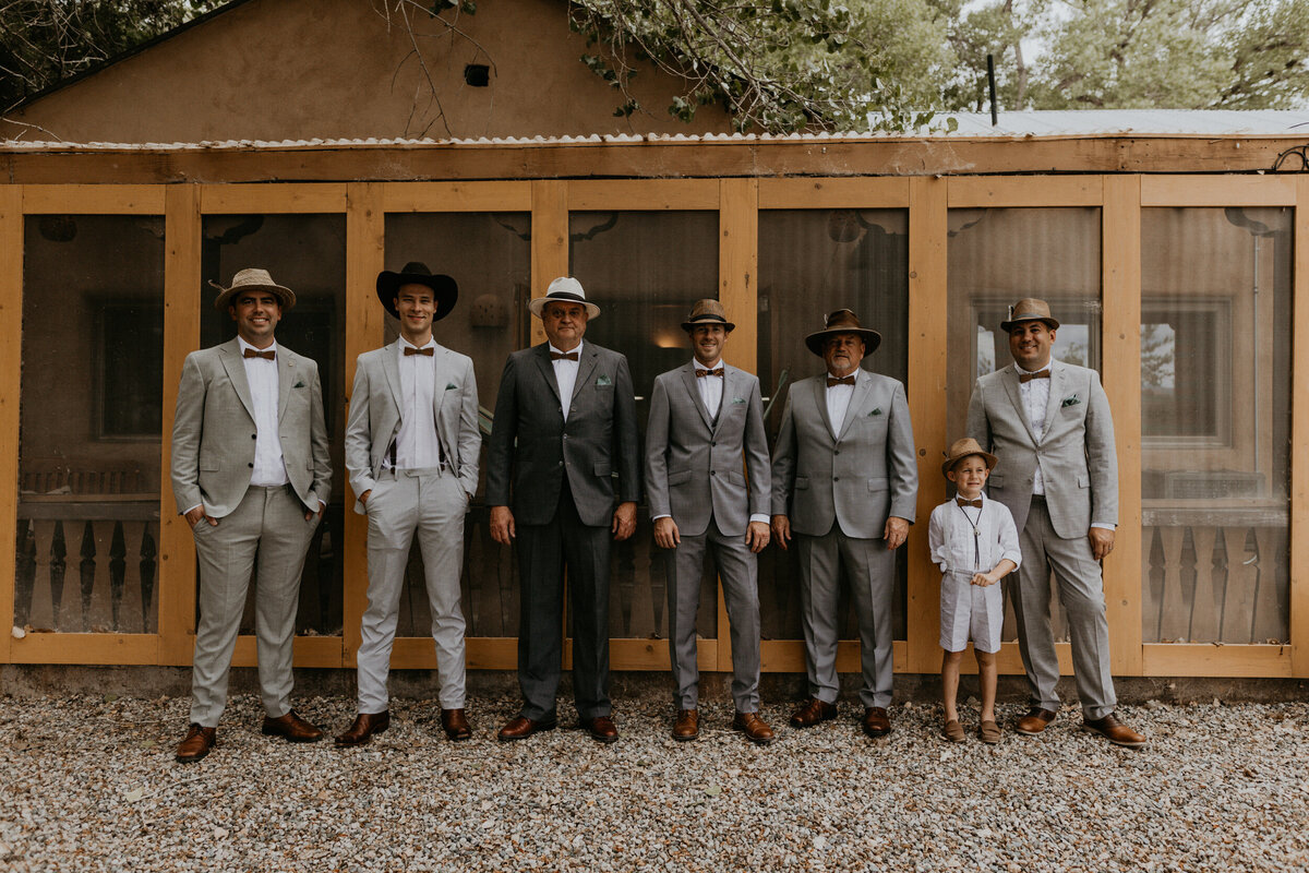 groom with groomsmen in gray suits and hats