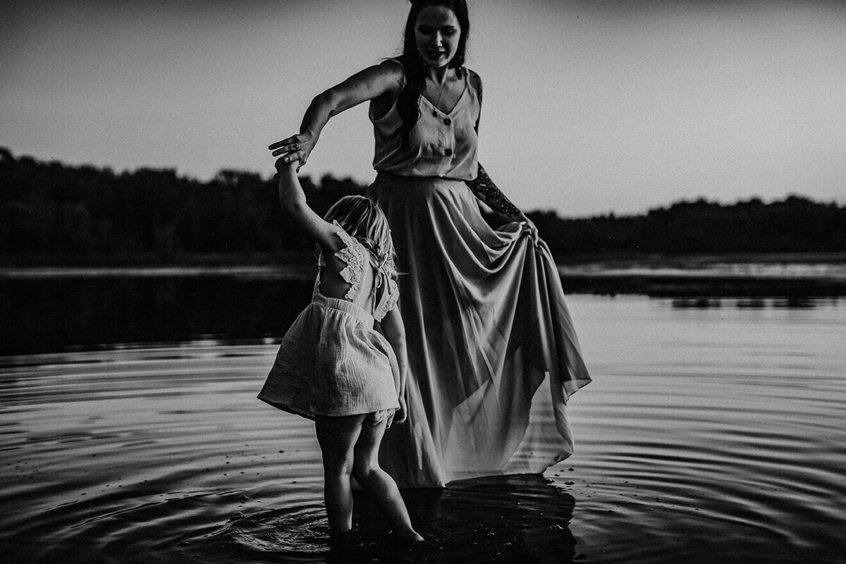mother and daughter dancing in water