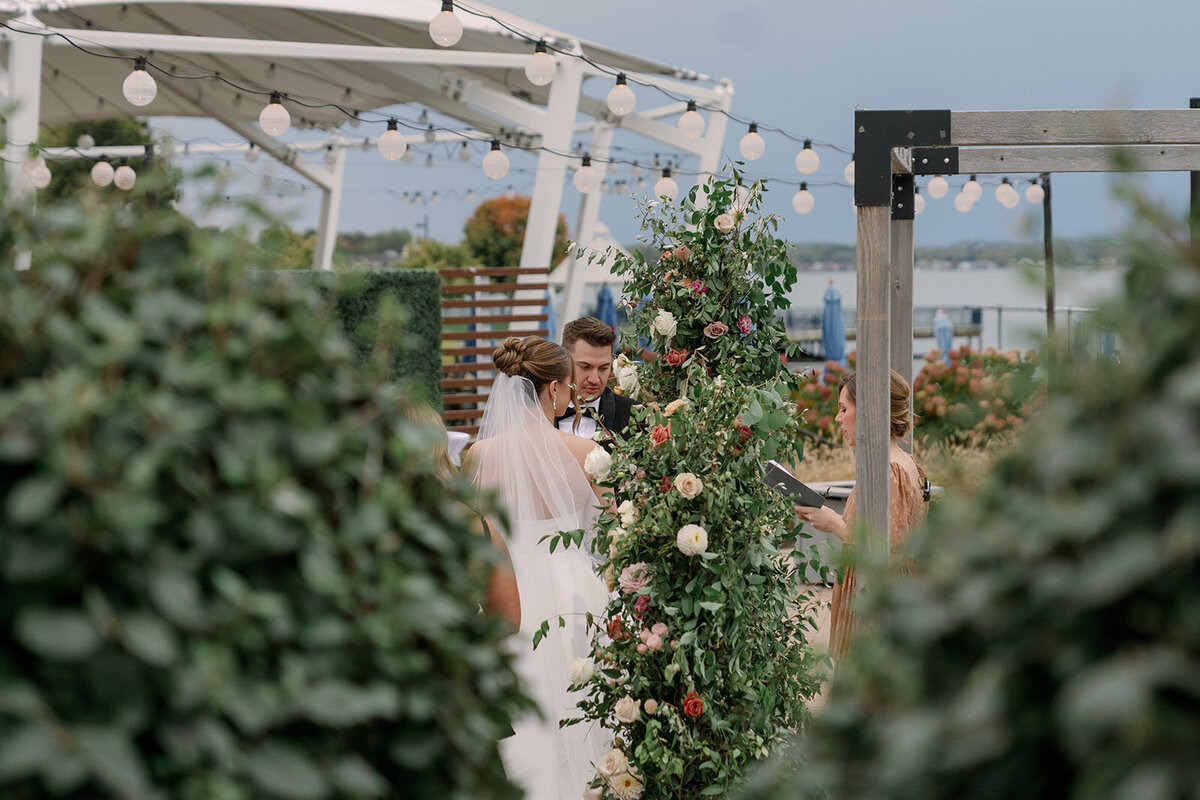 Ceremony aisle at Boatwerks in Holland Michigan with floral arrangements and lakefront backdrop for a summer Michigan wedding.