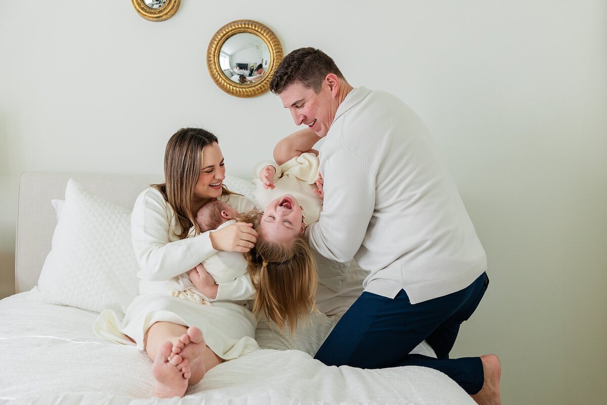 family laughs in bed