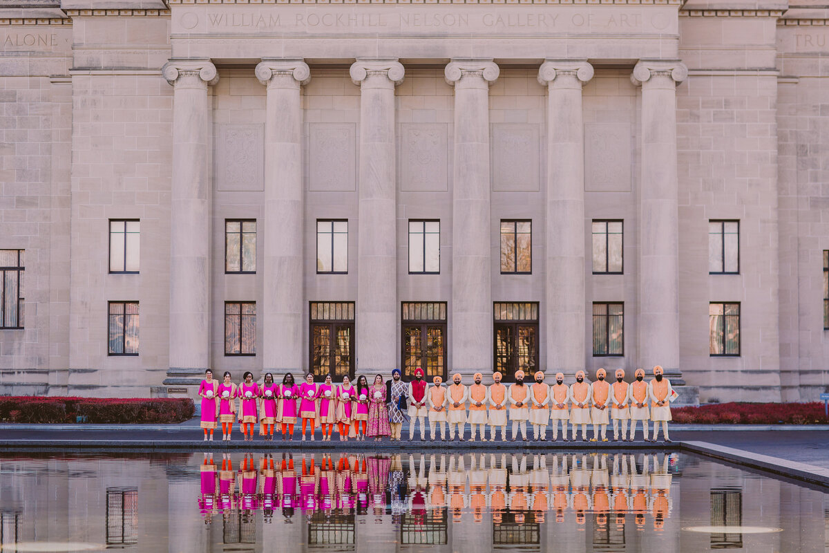 A sikh wedding bridal party reflecting across the pool at the nelson atkins museum in kansas city