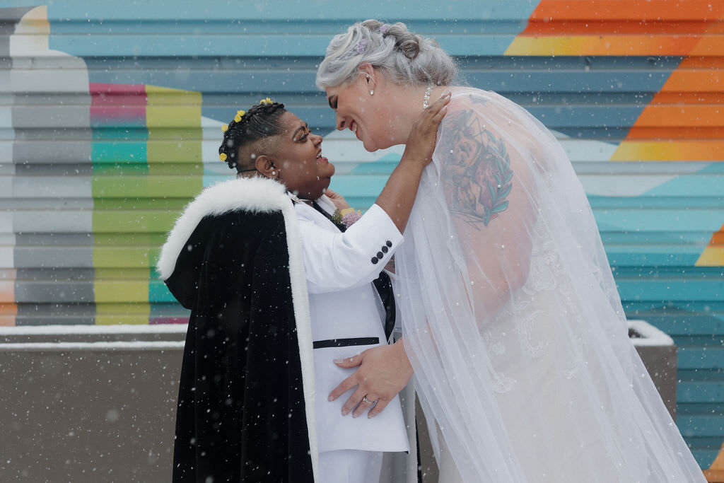 A newlywed couple about to kiss.