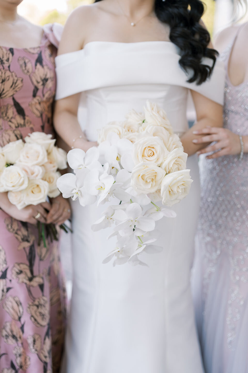 An elegant cascading bouquet with garden roses and orchids in a loose, flowing design.