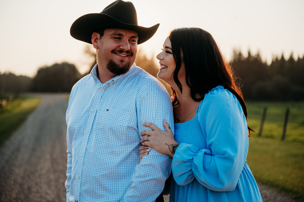 engaged couple look at each other and laugh