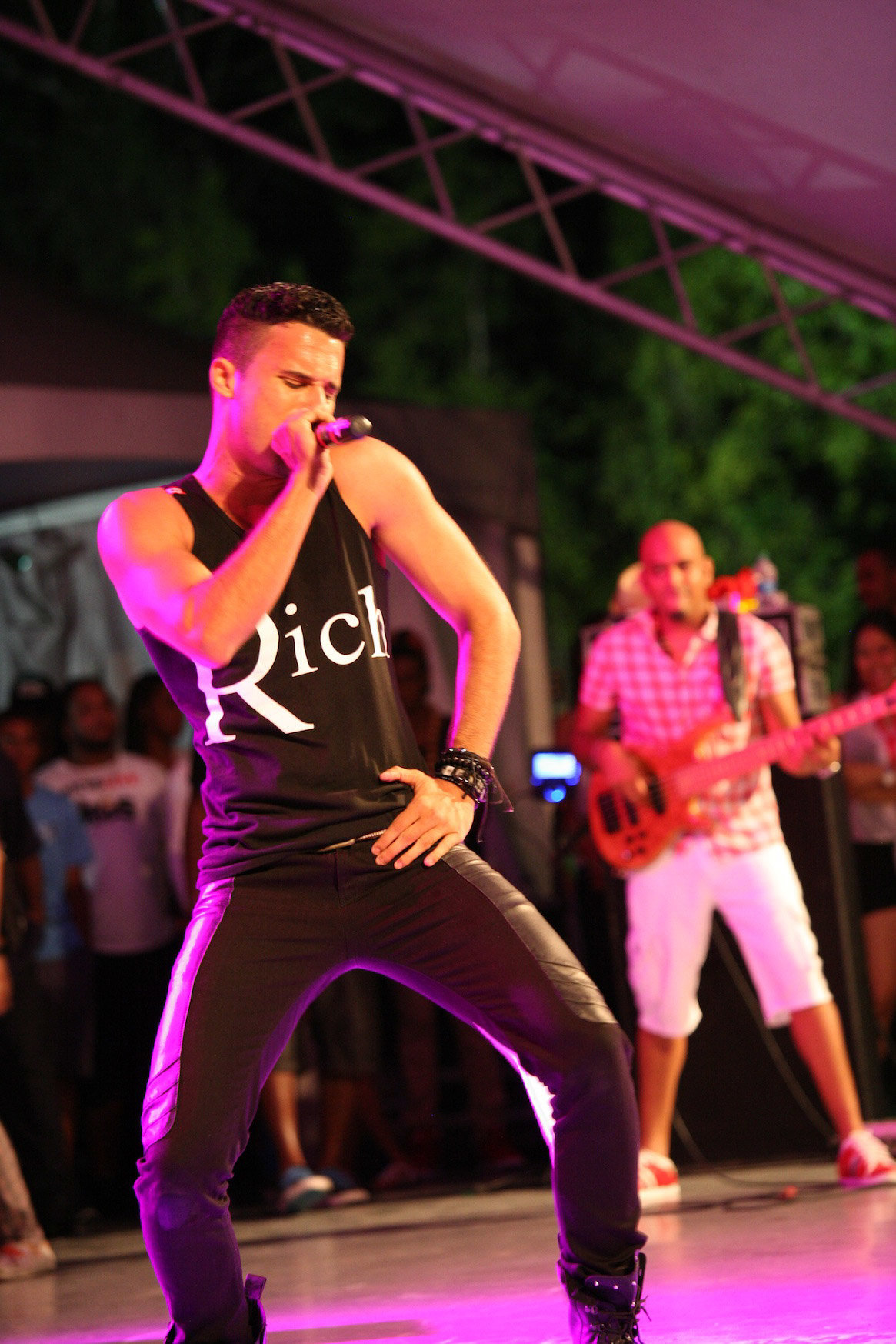 Image of young singer dancing on stage with guitarist in the backgorund. Photo by Ross Photography, Trinidad, W.I..