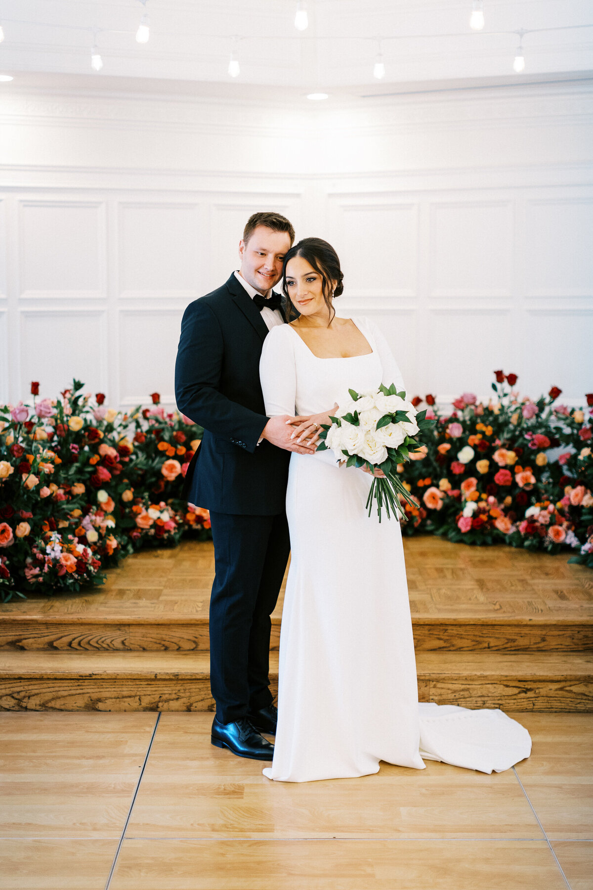 Bride and Groom posing for  Toly Dzyuba Photography surrounded  with beautiful roses at St Paul College Club.