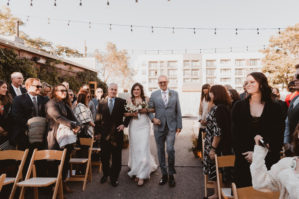 Bride walks down the aisle with her father on her wedding day at Blanc Denver.