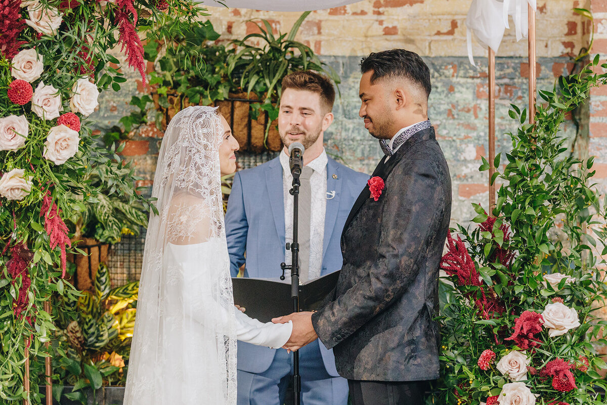 bride and groom holding hands at the alter