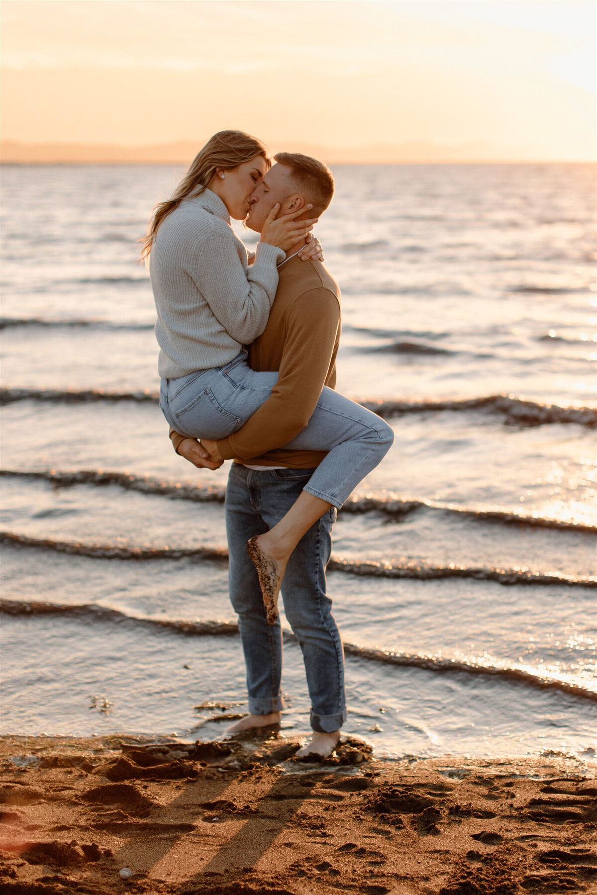 Couple kissing on the beach during golden hour, captured by Bronte Taylor Photography, a Vancouver-based photographer with a playful, genuine and intimate approach.
