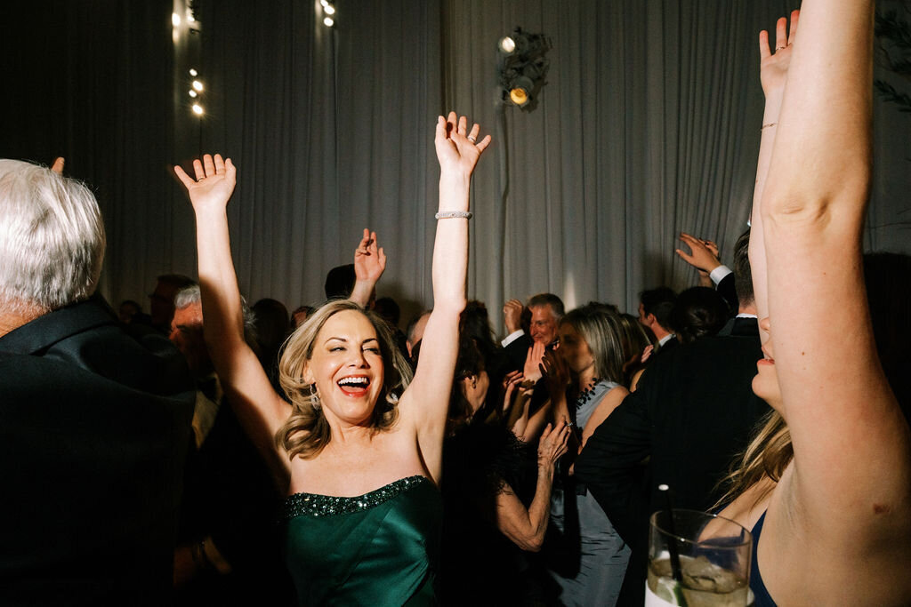 Mother of the bride dancing with her hands in the air. 