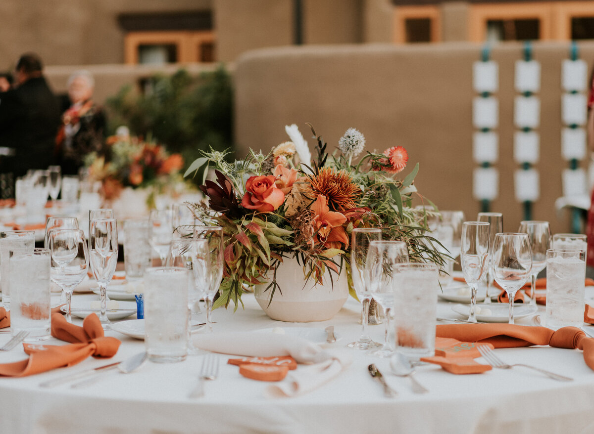 White, orange, and green boho wedding reception tablescape.