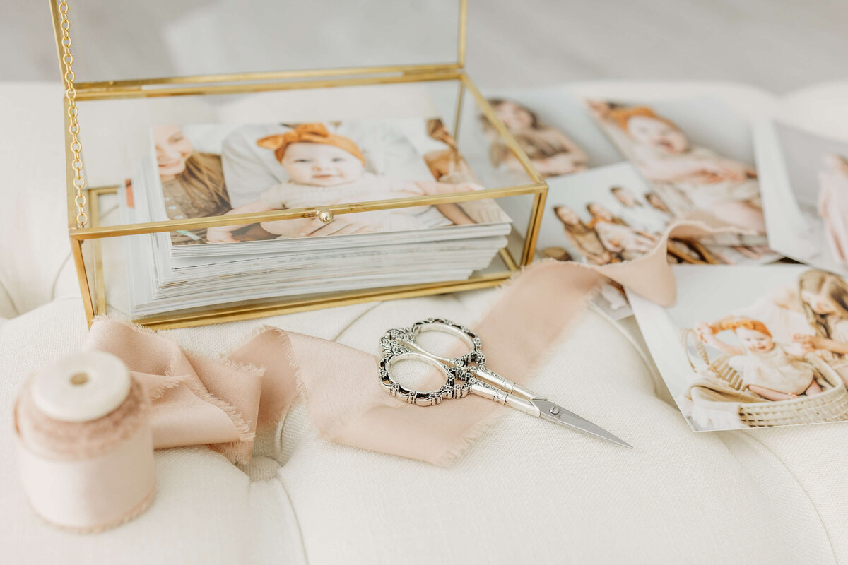 Display of peach ribbon and scissors along with scattered prints