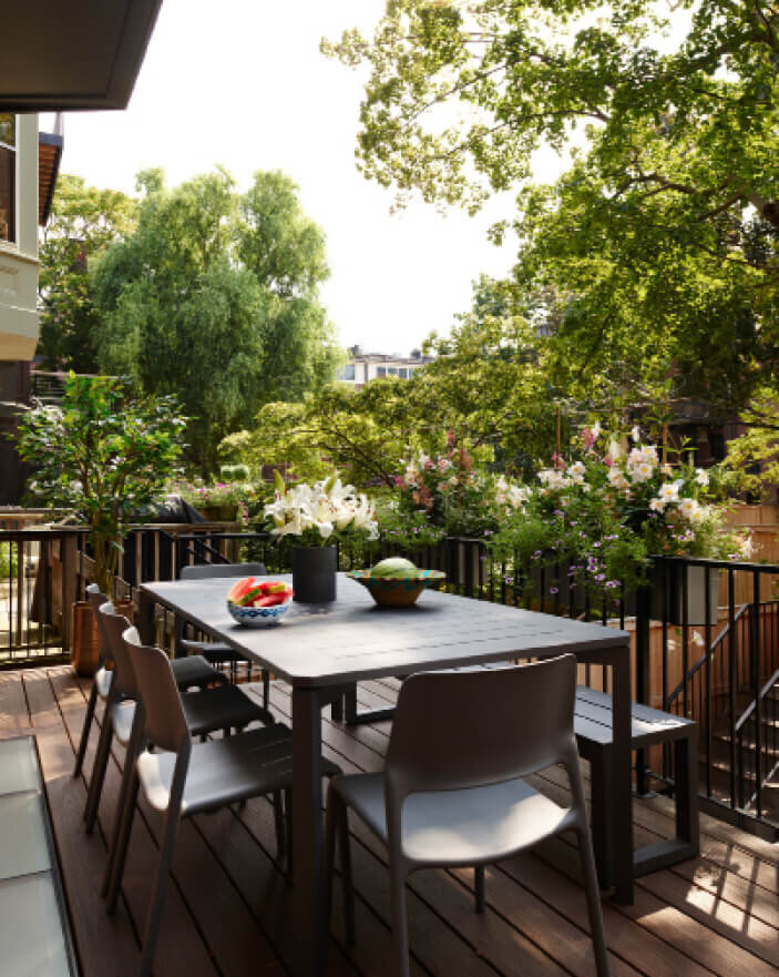 Boston Residential Designer designed a new deck at a brownstone renovation project with modern furniture and views of mature gardens and trees.