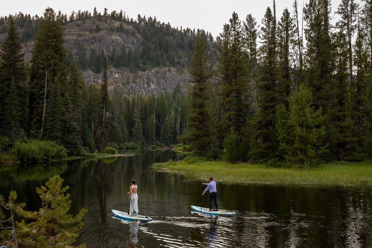 A bride and groom paddle around a lake on their Idaho elopement day.