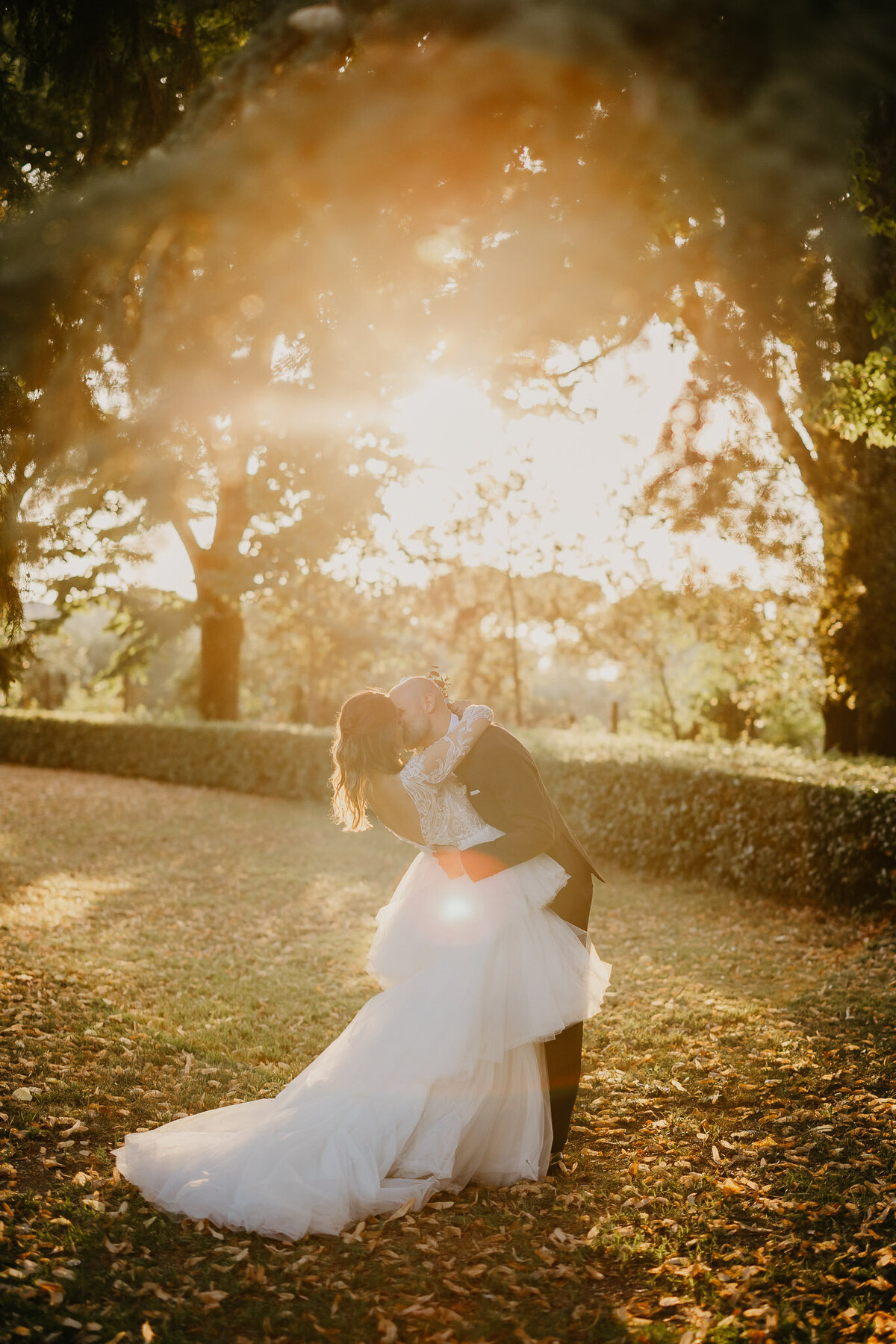 Bride and groom kissing at romantic sunset in Villa Corsini Mezzomonte garden, wedding photographer Tuscany Florence.