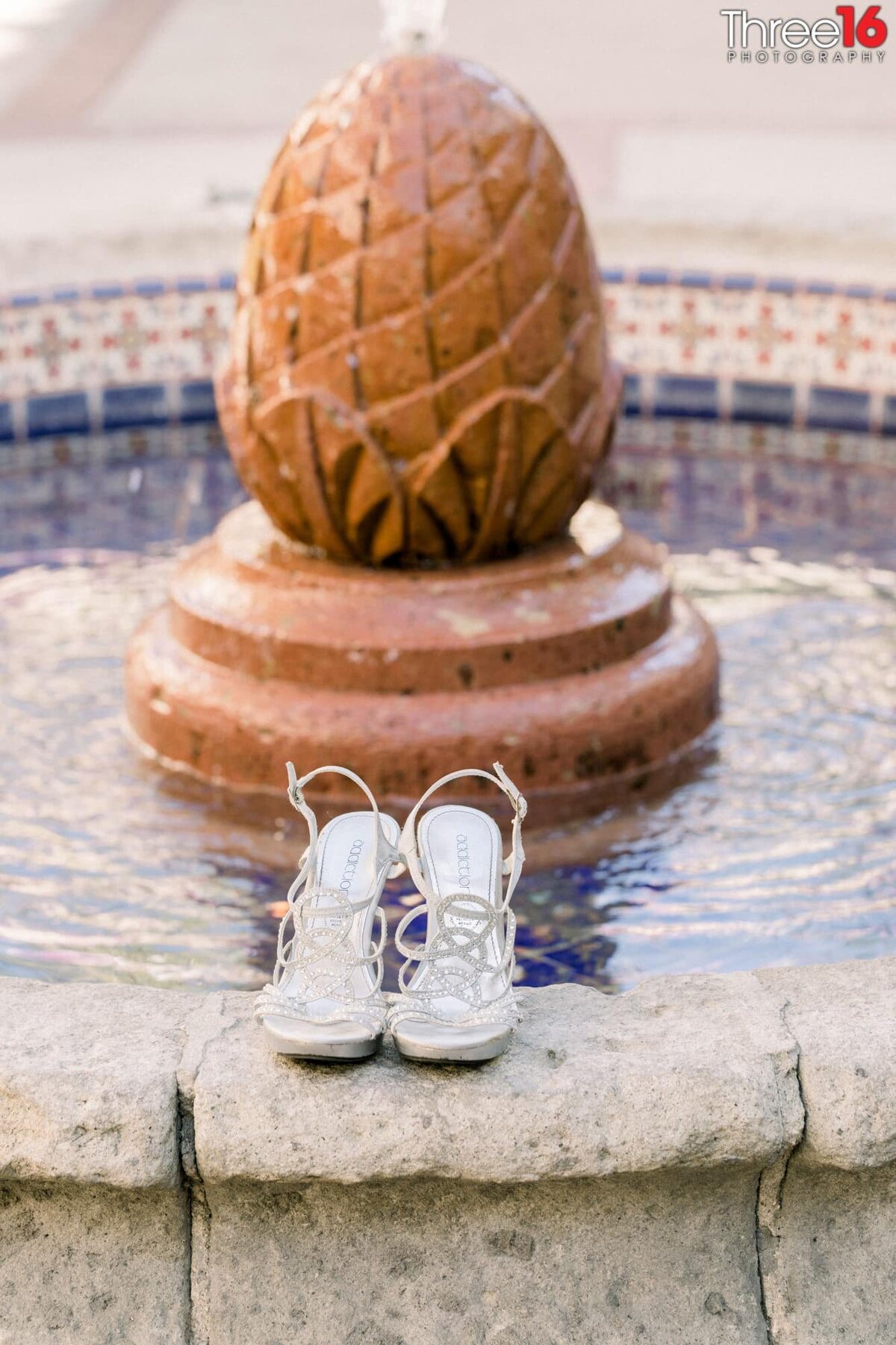 Bride's wedding shoes on the edge of the water fountain