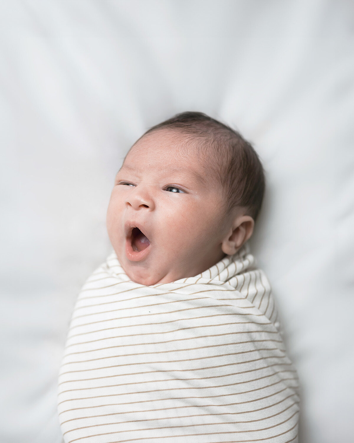 Newborn yawning at home in San Francisco for an in-home photography session.