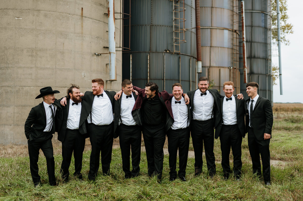 Groomsmen lined up in front of stone building