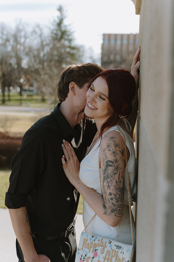 A man kisses the cheek of his new wife on their elopement day. The photo is angled so you can't see his face.
