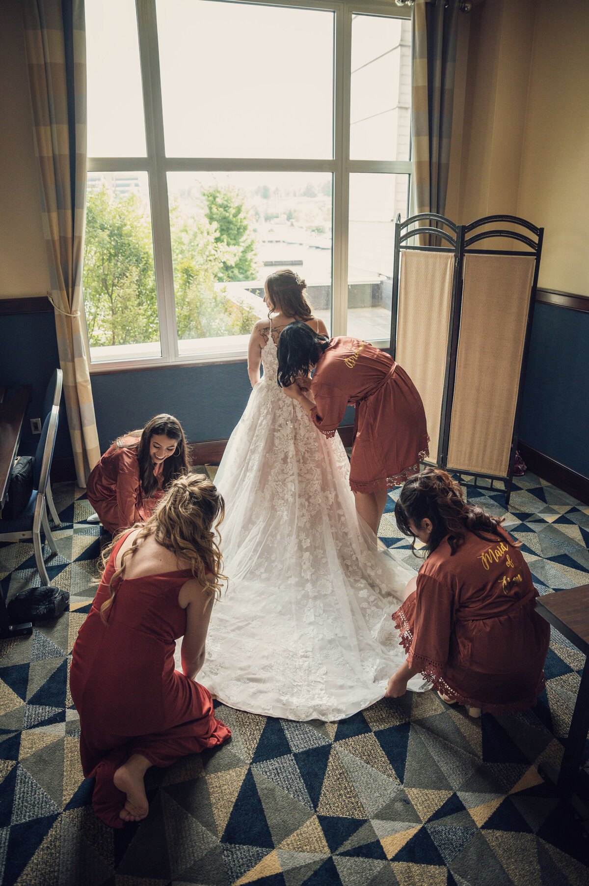 Bridesmaids fixing brides wedding dress at Sheraton Bayfront Erie.