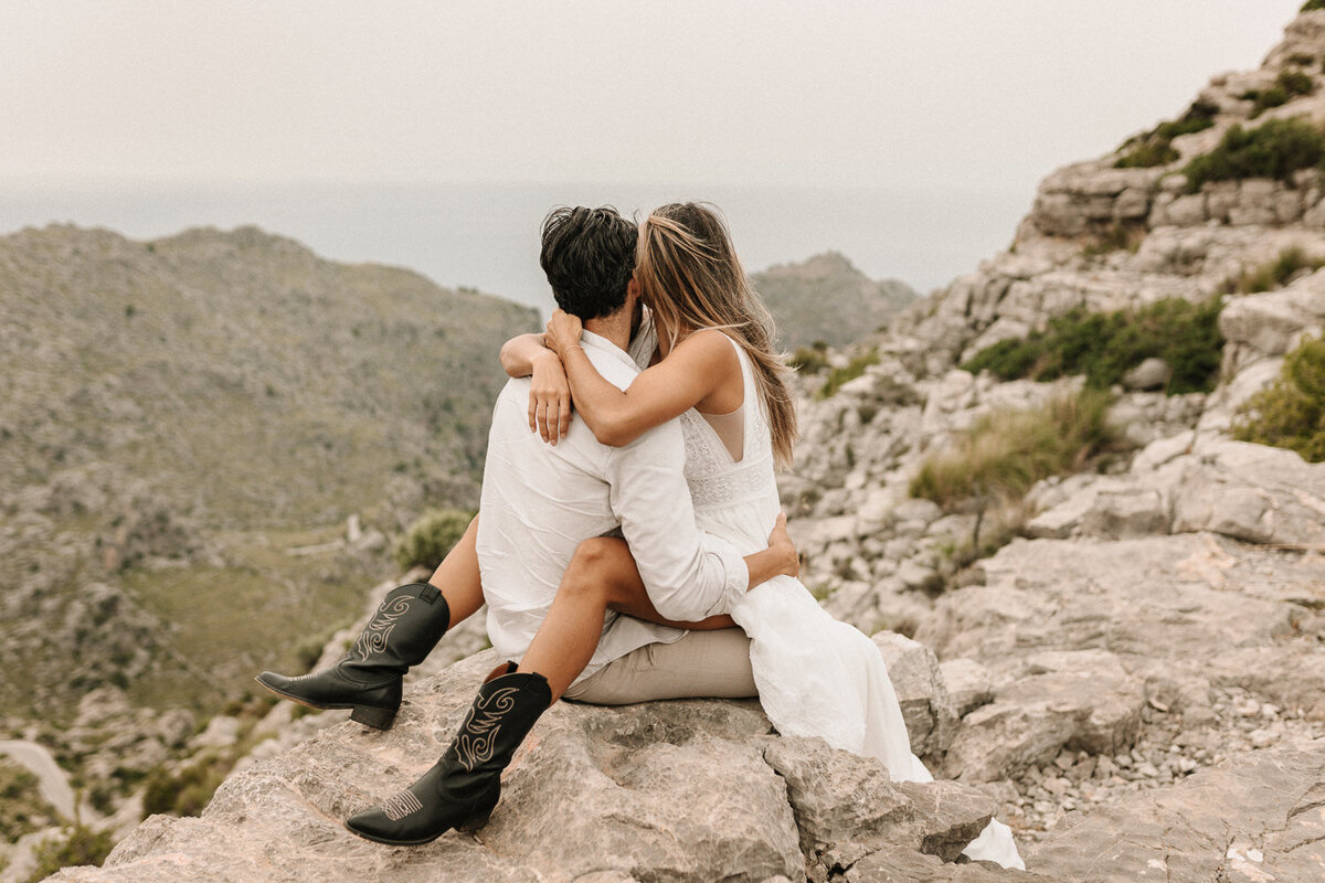 Brautpaar sitzt auf einem Felsen im Tramuntana Gebirge auf Mallorca