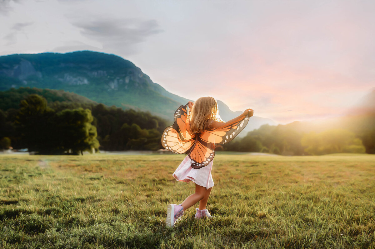 Little girl frolics on a mountain top during Family Photoshoot in Asheville, NC.