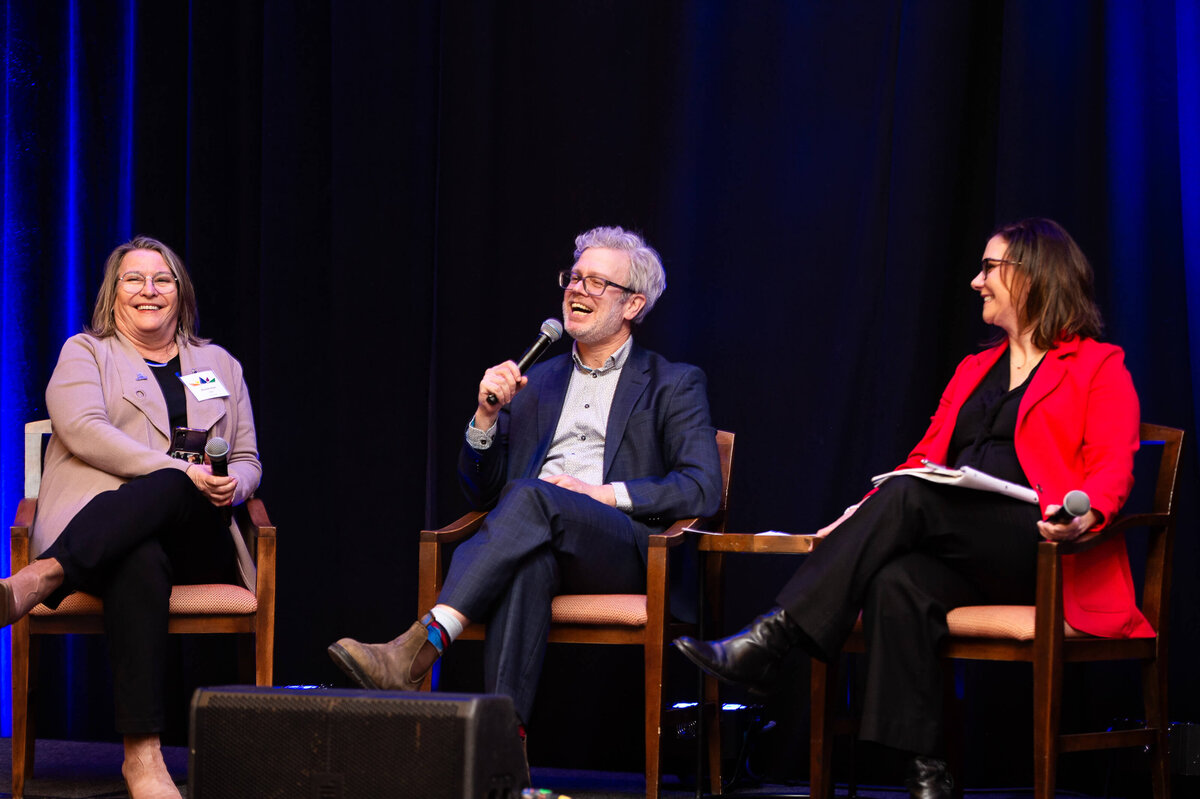 a man in a blue suit speaking into a microphone during a panel discussion at a 2-day corporate event at the Westin Hotel.  Captured by Ottawa Event Photographer JEMMAN Photography COMMERCIAL