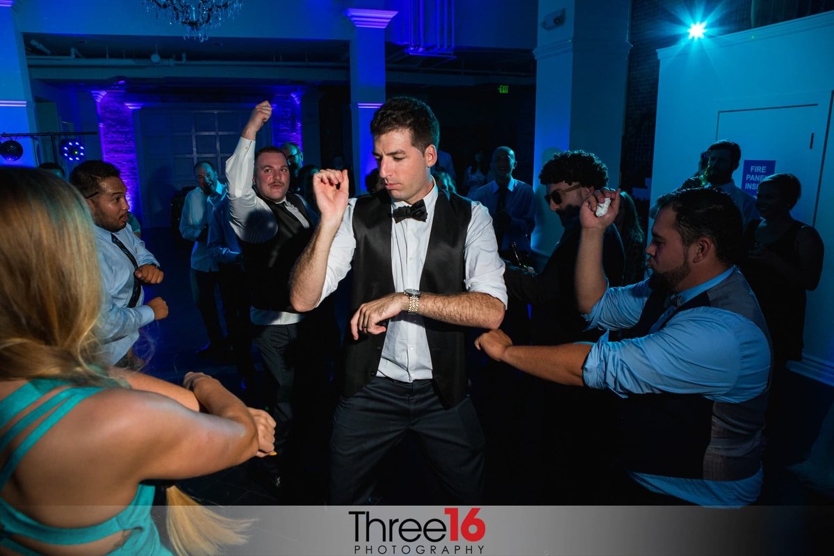 Groom is in the middle of the dance floor showing his moves