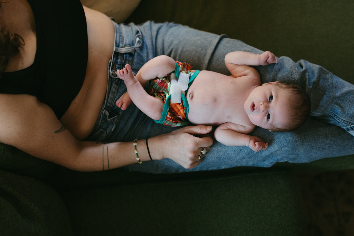 Newborn baby on his mother's lap during a family photoshoot at home in Portland, Oregon.