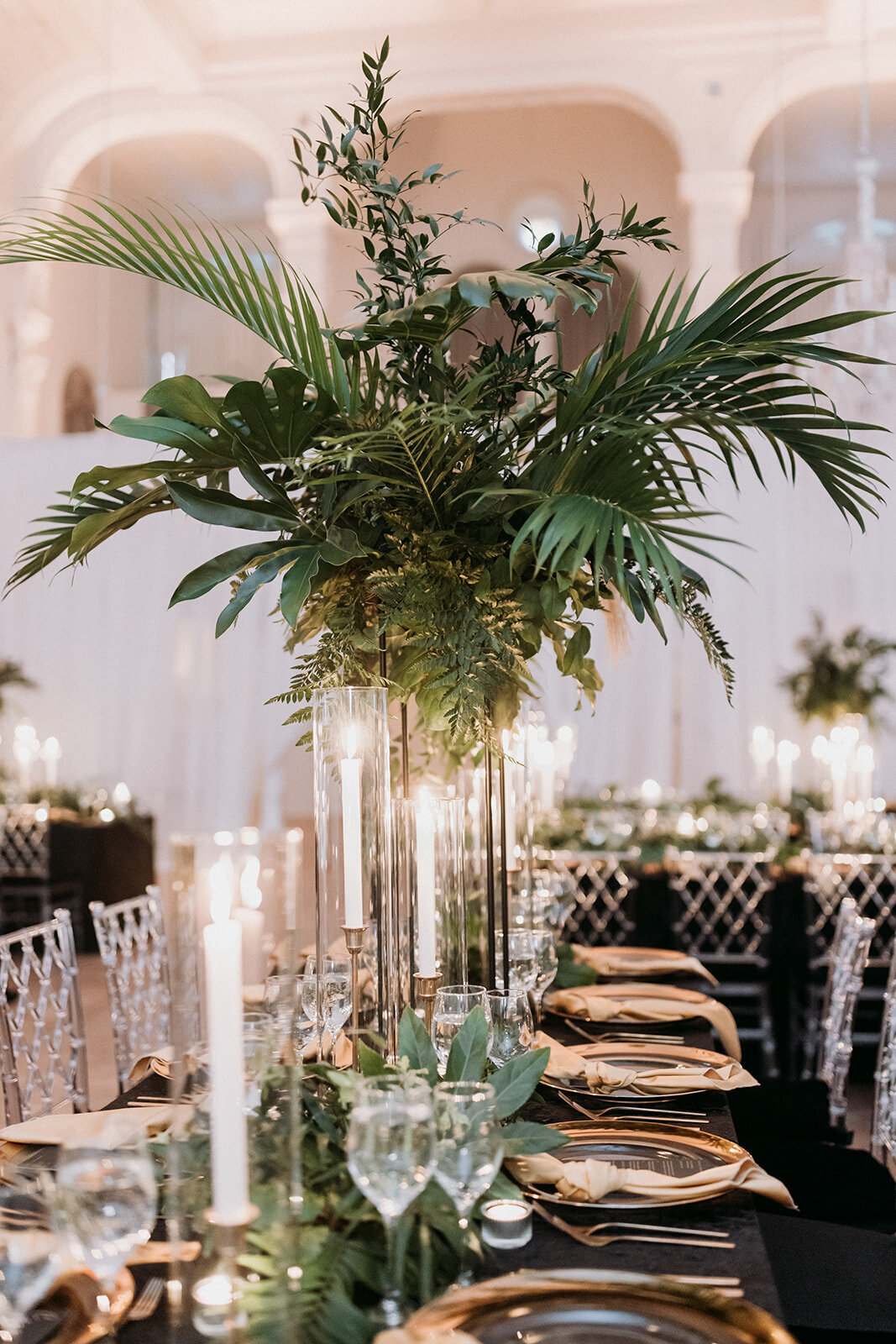Centrepieces of exotic greenery are elevated above a wedding reception table at Maison Principale. 