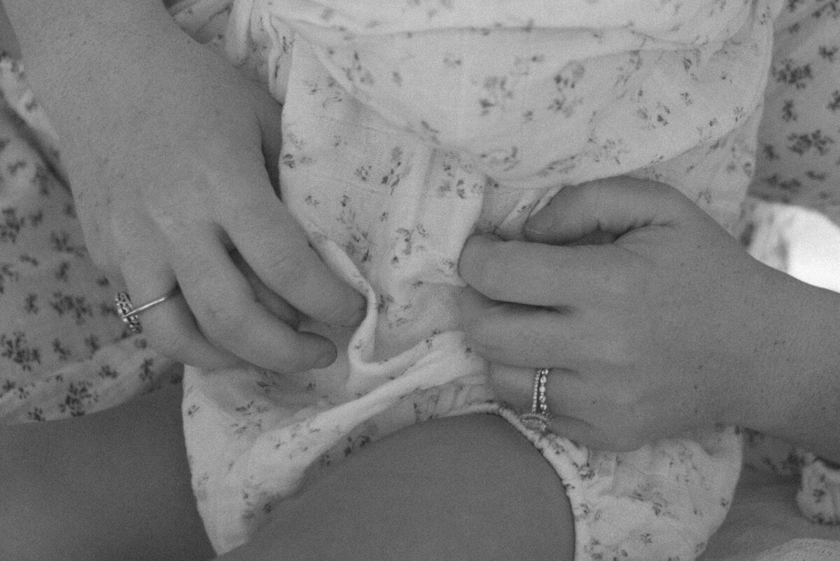 black and white closeup up a mother tickling her daughter on the belly.