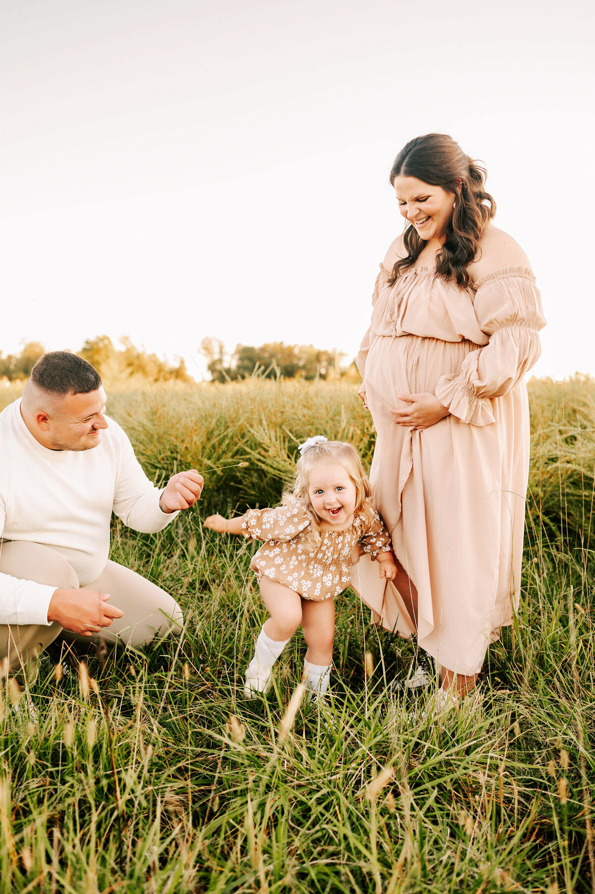 toddler laughing with pregnant parents during Joplin MO maternity photography session