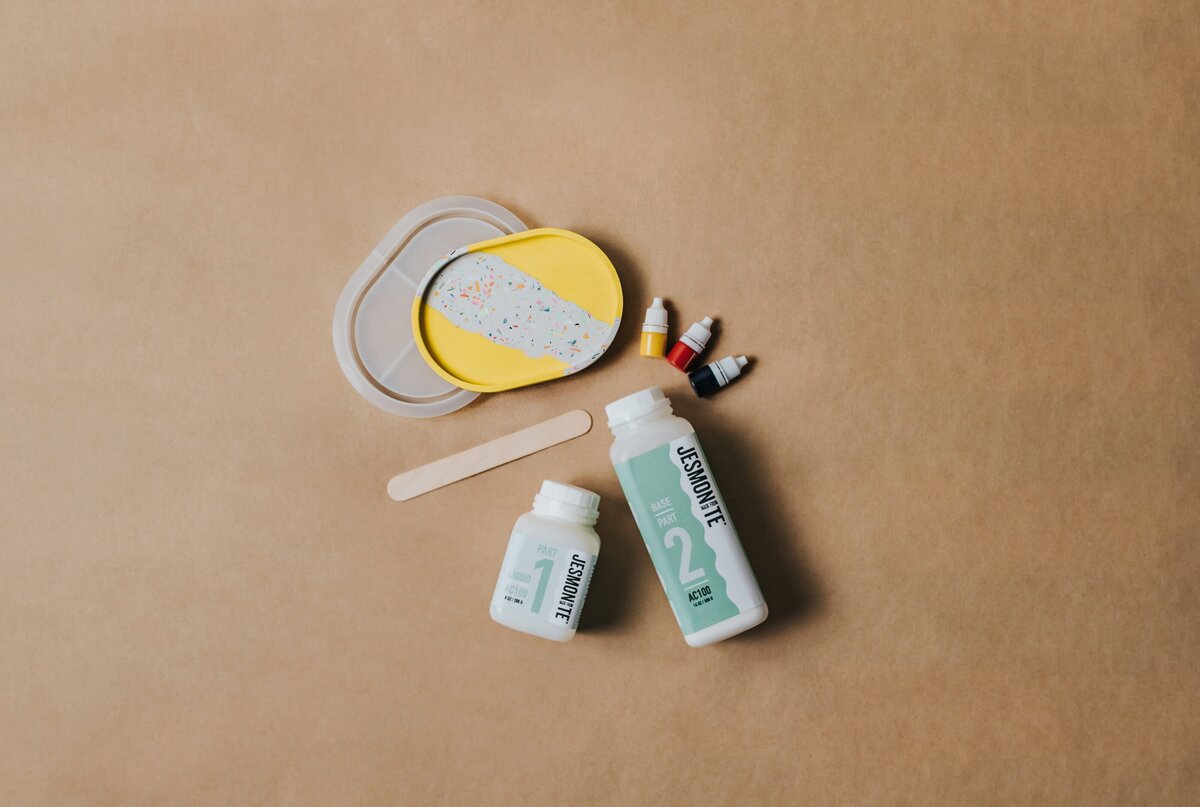 Craft paper backdrop featuring a flat-lay of silicone molds and paint products.