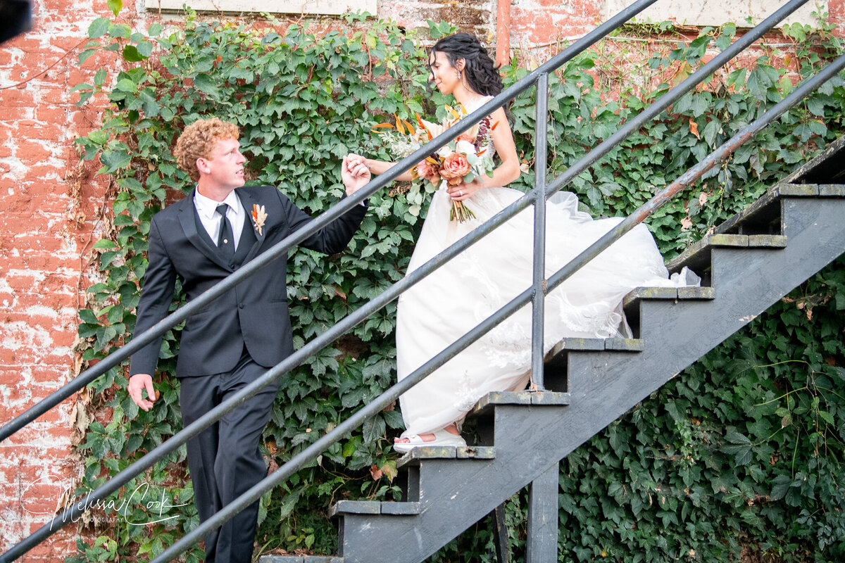 Groom leading Bride down stairs