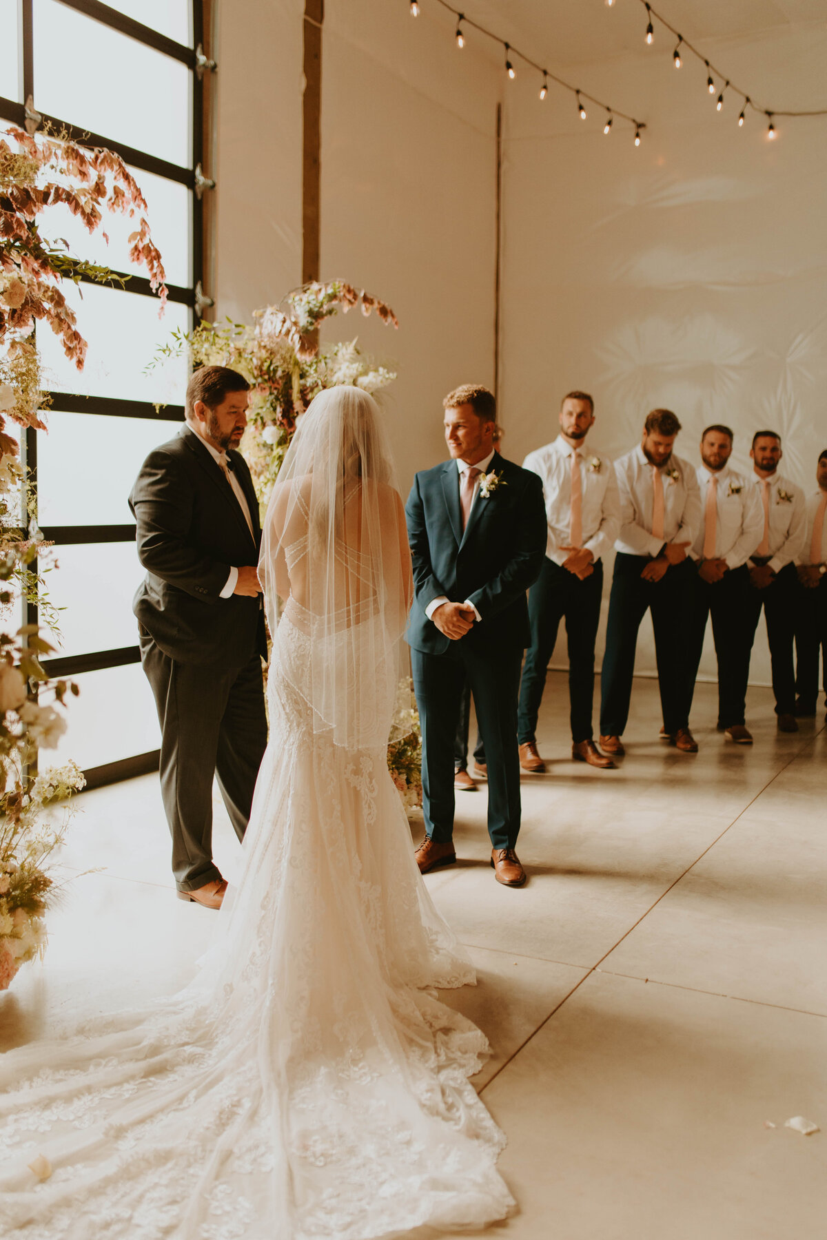 The couple with groomsmen behind, standing at the altar.